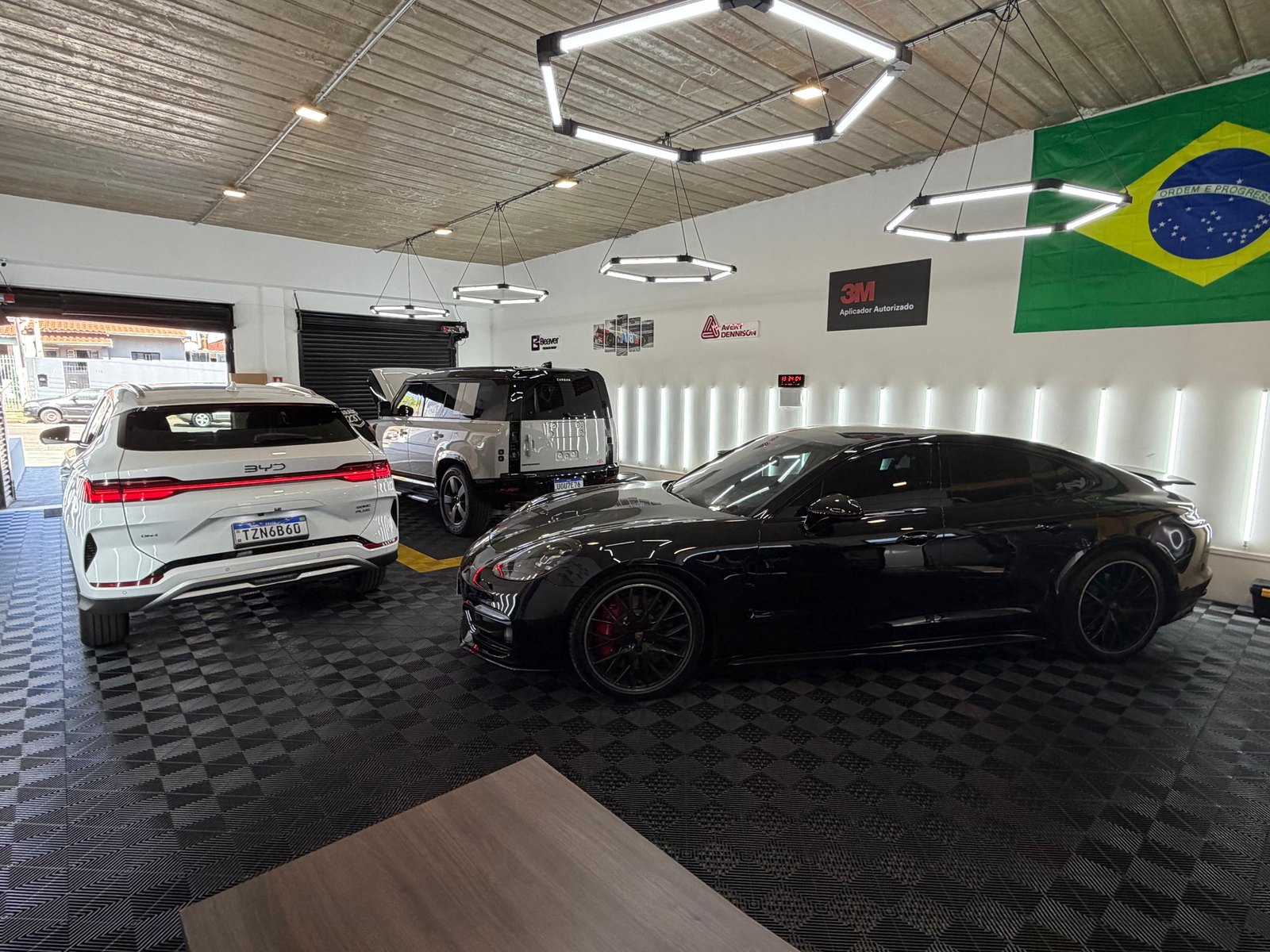 Interior da Garage 237 com carros na área de aplicação e o selo de aplicador autorizado 3M na parede
