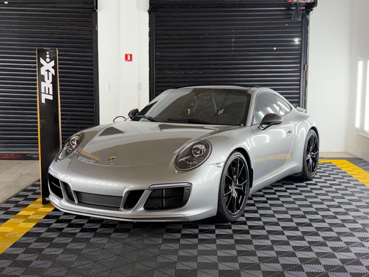 Porsche 911 prata dentro da Garage 237, ao lado do totem XPEL